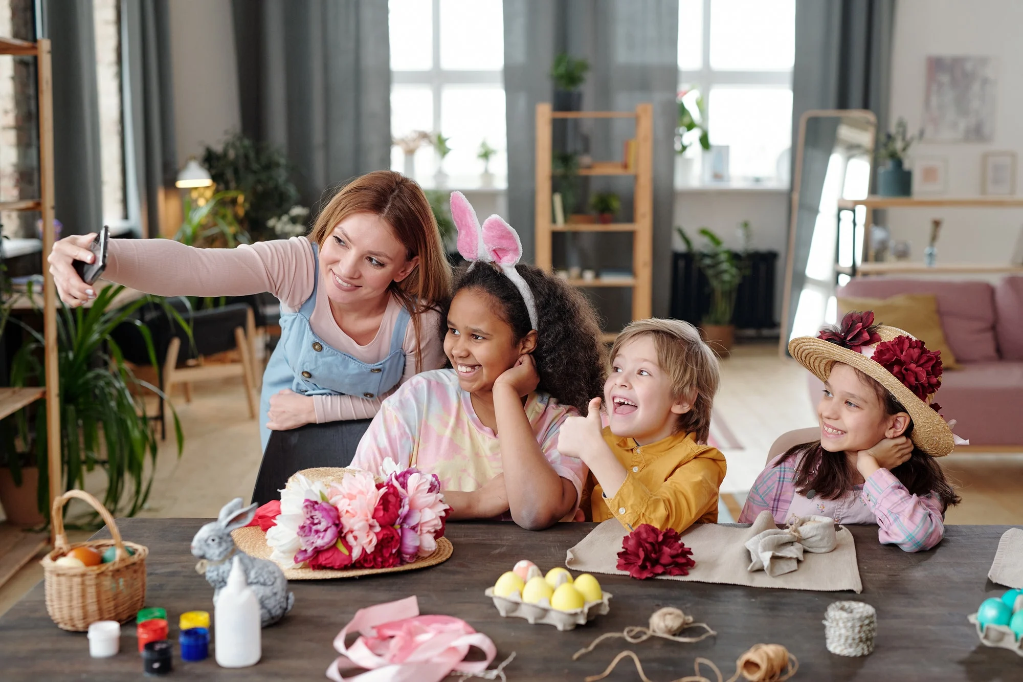 Three cute little children and a young blond female in casualwear taking a selfie together, promoting optimal health for children and young adults.