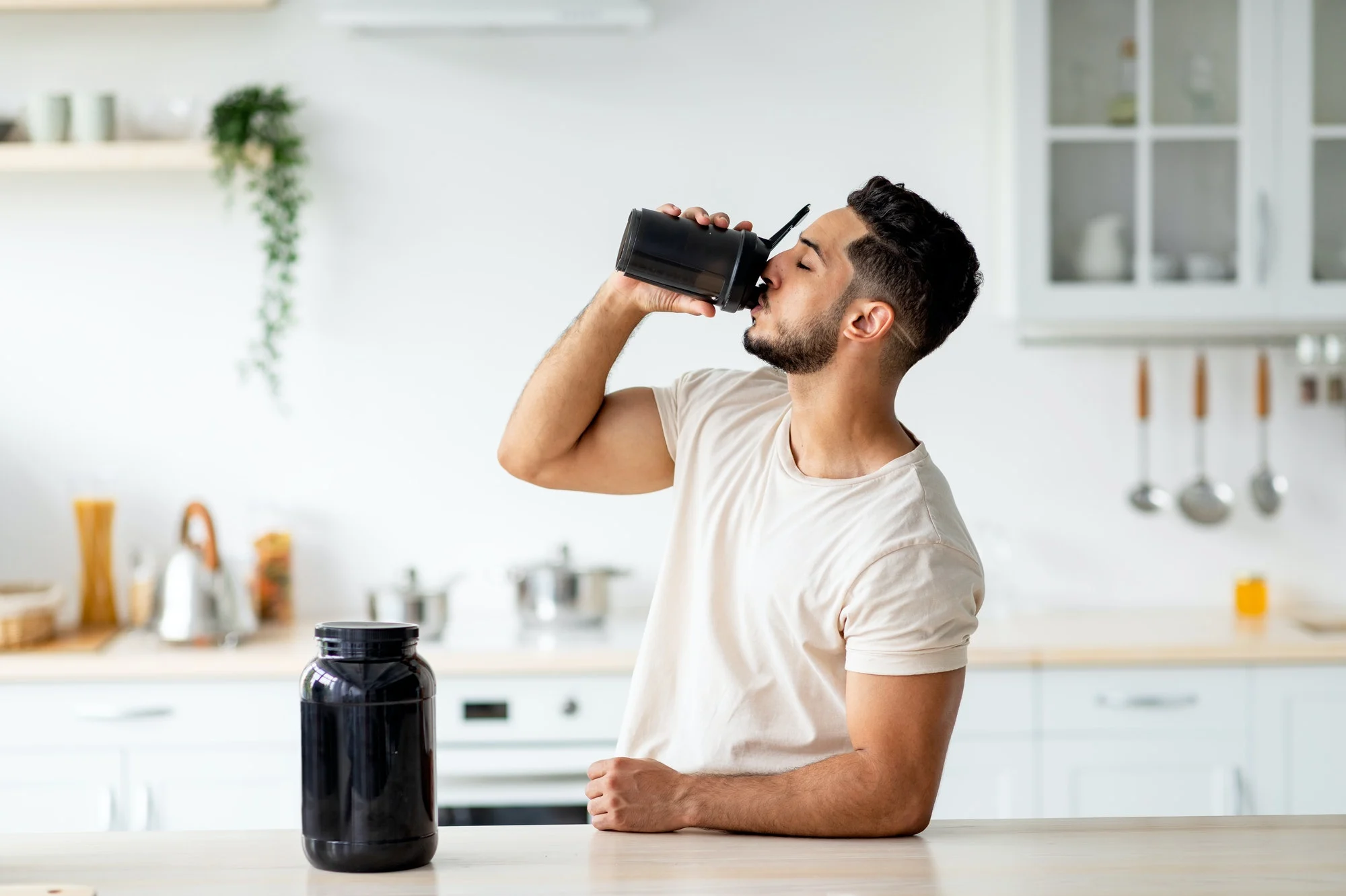 Man Drinking Protein Shake for Body Care and Wellness: Copy Space Kitchen Scene - Proper Protein to Become an Optimal Human